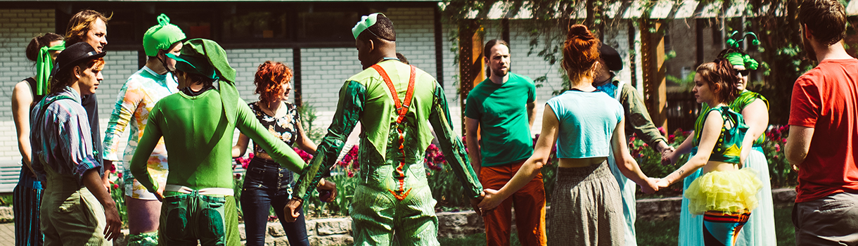 Participants wearing green stand in a circle