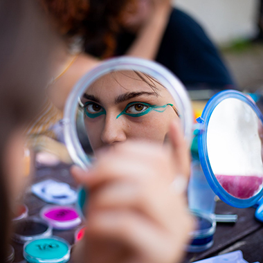 A participant's eyes as she is putting on makeup in a mirror